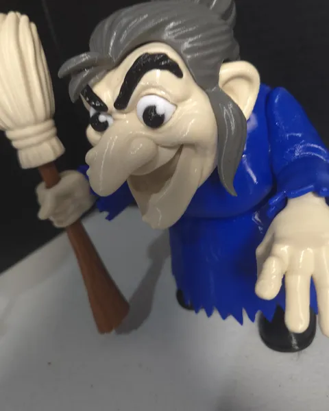 Witch figure in a blue robe holding a broom
